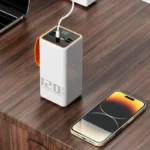Sleek white power bank with orange accent next to smartphone, ideal for modern professionals.